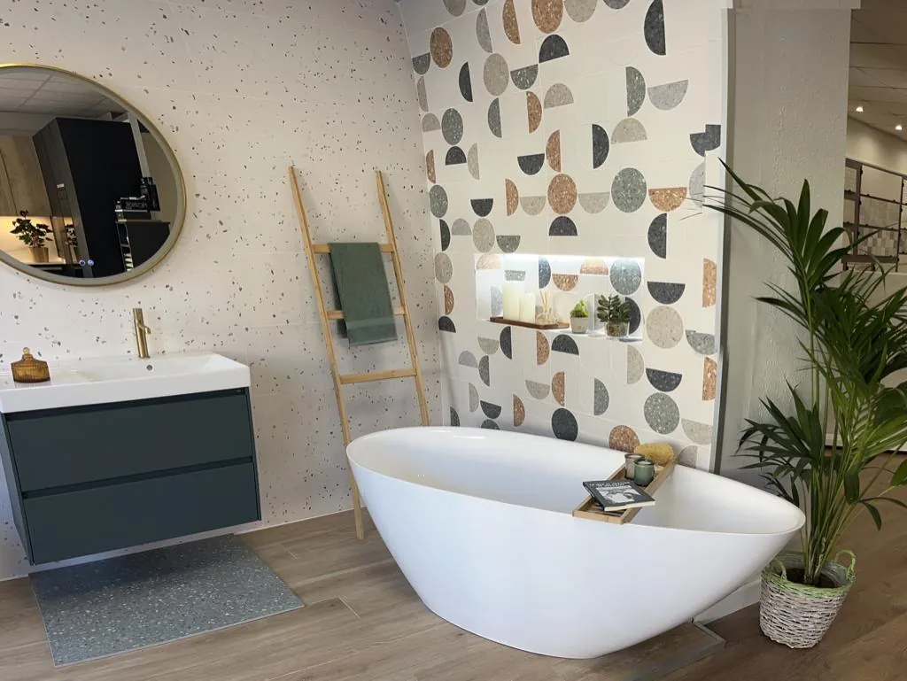 Bañera exenta y mueble azul con pared decorada
