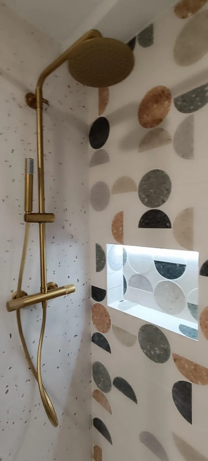 Ducha con grifería de latón y azulejo de círculos