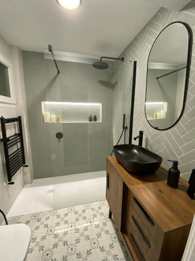 Ducha con nicho y mueble de madera en tonos salvia