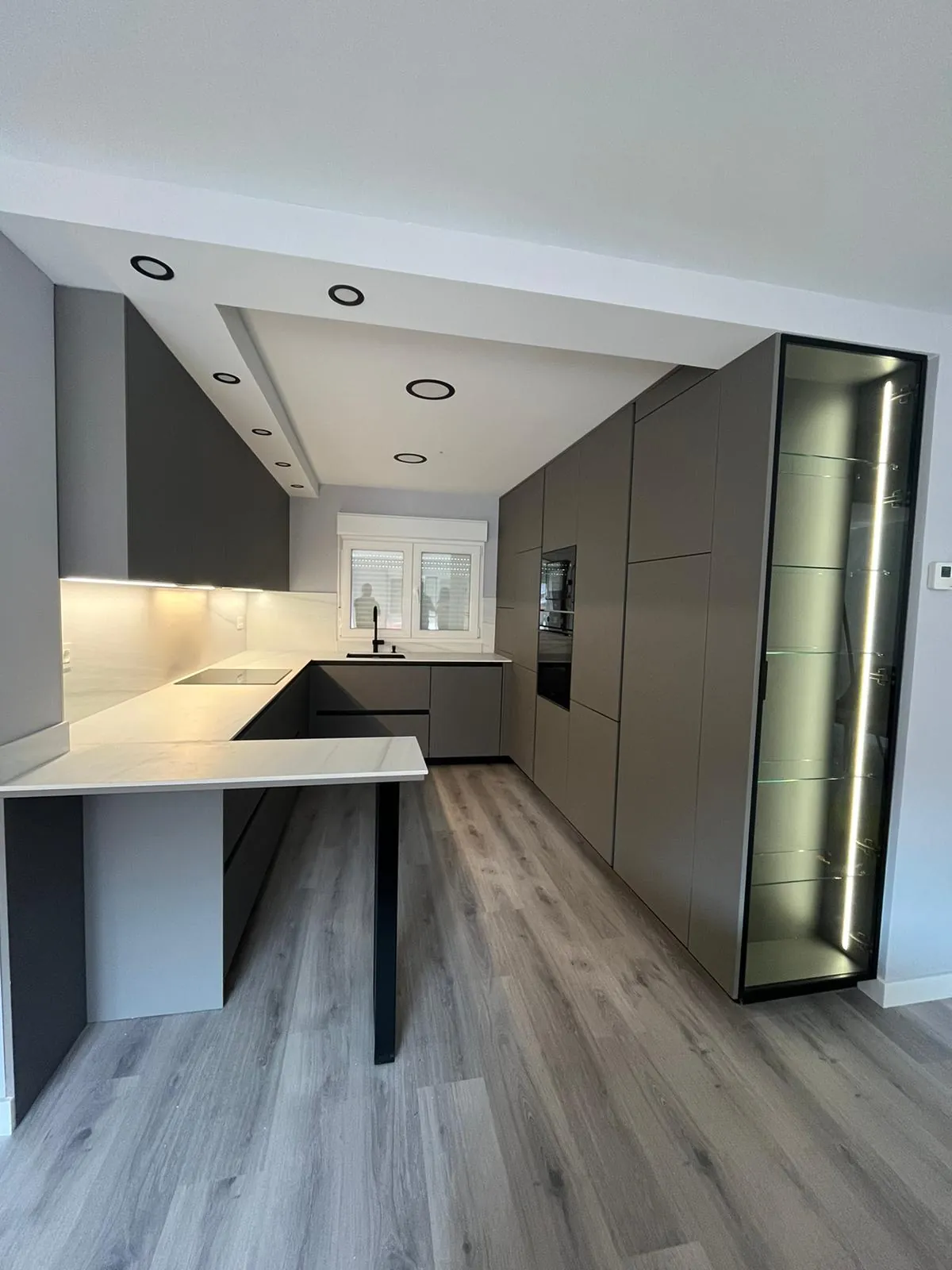 Cocina moderna con península oscura e iluminación LED integrada