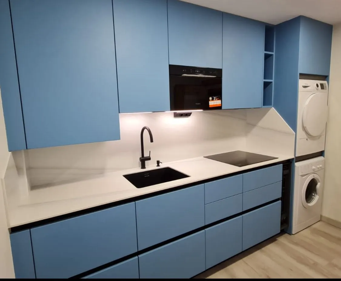 Cocina azul petróleo con electrodomésticos integrados
