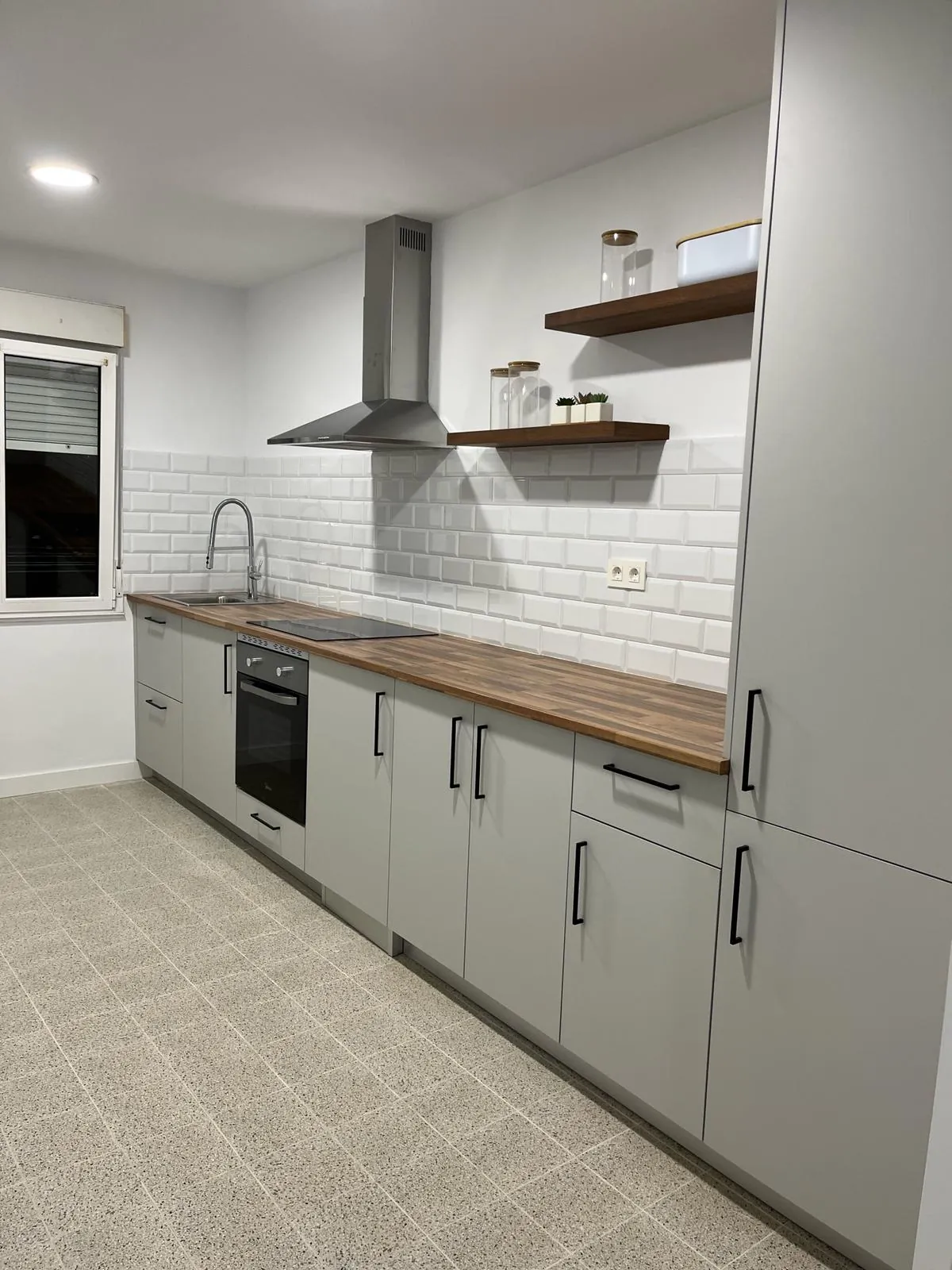 Cocina blanca con azulejo tipo metro y campana vista