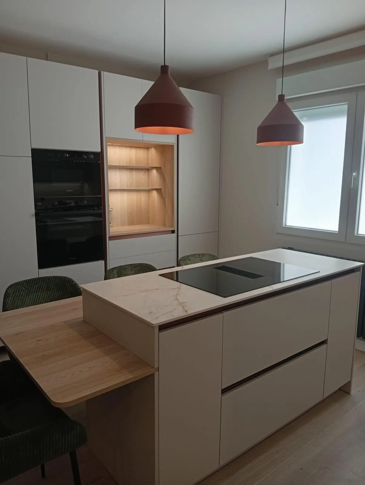Reforma de cocina moderna sin tiradores con isla, encimera clara veteada y mesa de roble